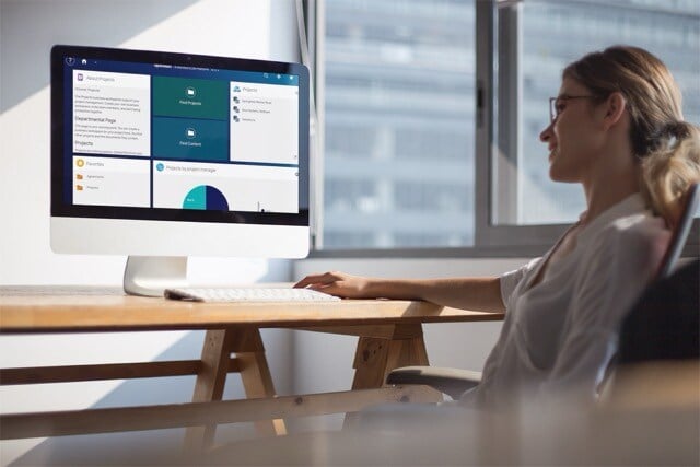 smiling-woman-working-on-an-imac-mockup-near-the-window-a20978_extended-ecm – middels
